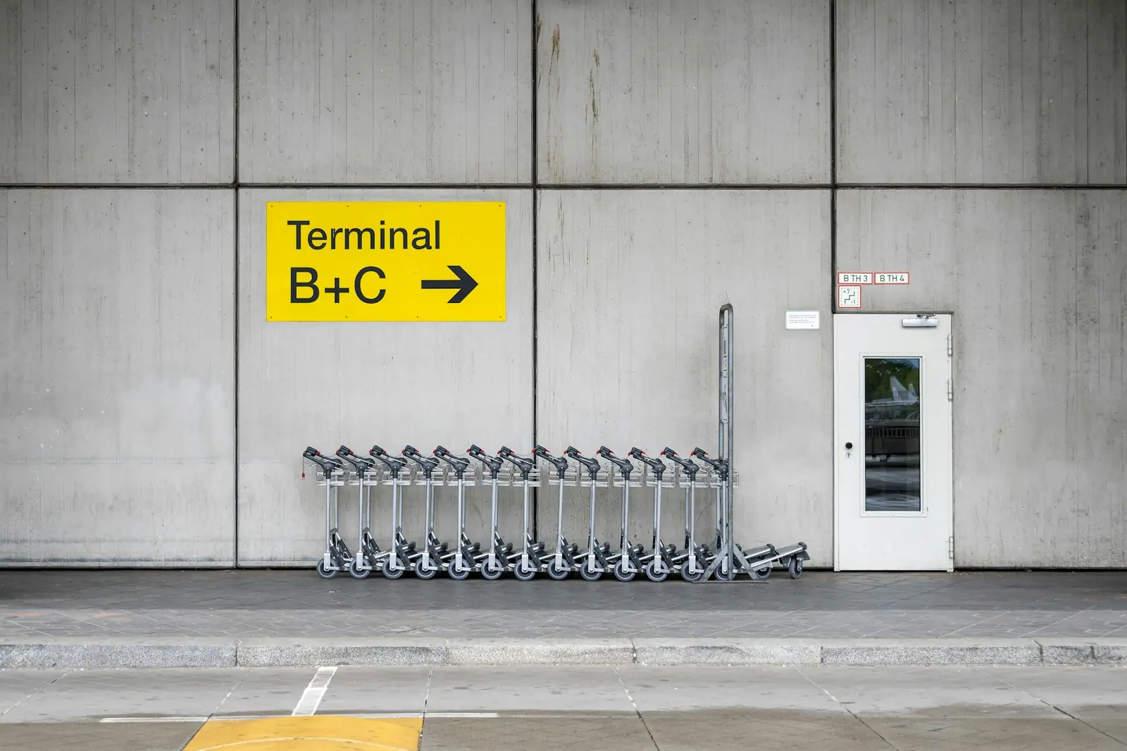 Havalimanı terminal yönlendirme tabelası ve bagaj arabaları