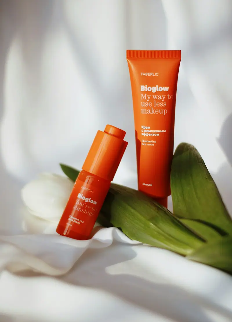 Beyaz kumaş üzerinde duran turuncu serum şişesi
